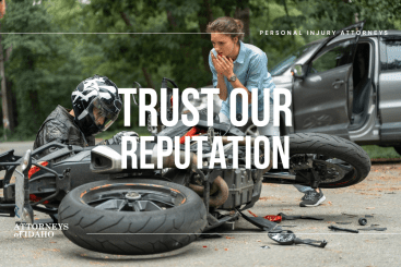Injured rider near damaged bike and car showing risks of motorcycle accidents in Boise